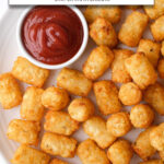 cooked tater tots on plate with small bowl of ketchup and text overlay 