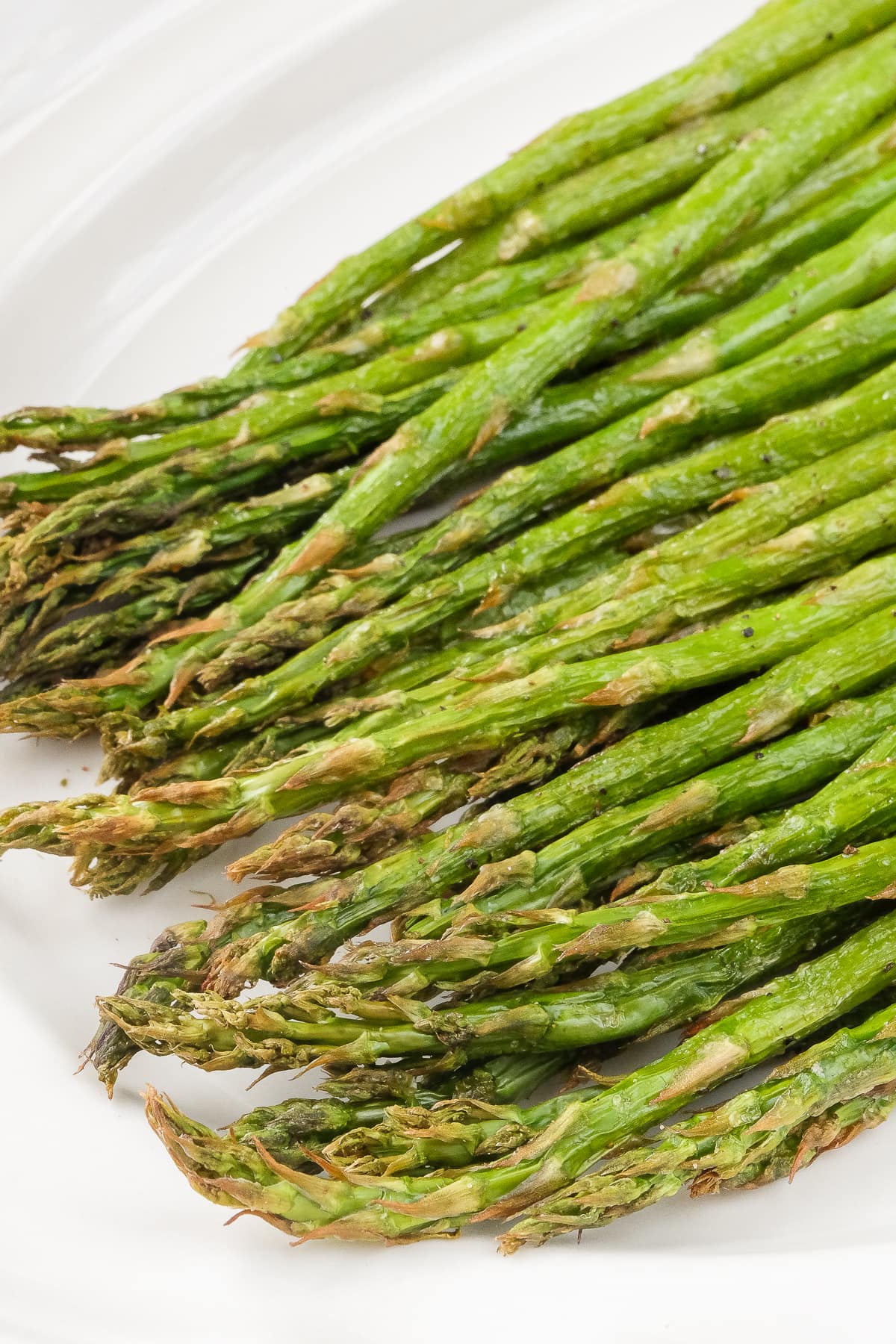 cooked asparagus on white serving dish