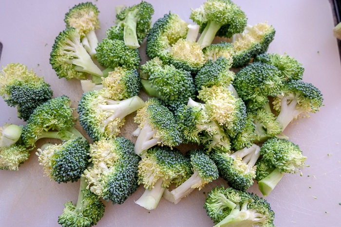 raw broccoli on white cutting board