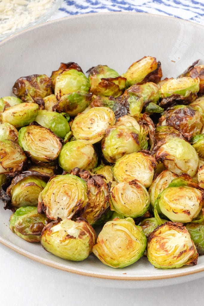 bowl of crispy brussels sprouts with blue towel behind
