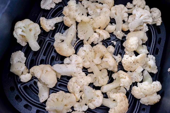 cauliflower bits in dark air fryer tray