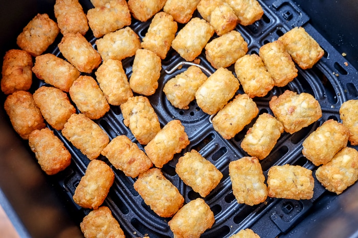 golden brown tater tots in air fryer tray