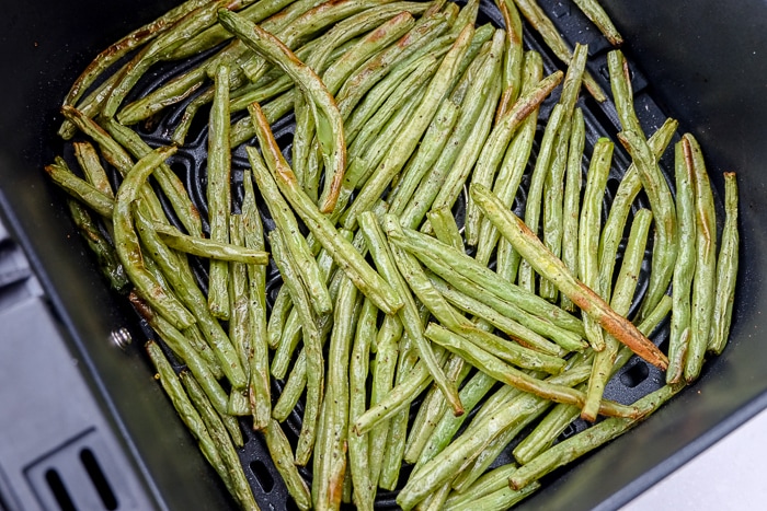 crispy green beans in black air fryer tray