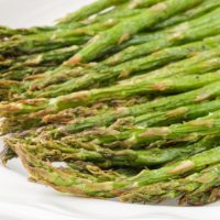green cooked asparagus on white serving dish