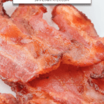 slices of cooked bacon on plate with blue rim and text overlay saying "air fryer bacon"