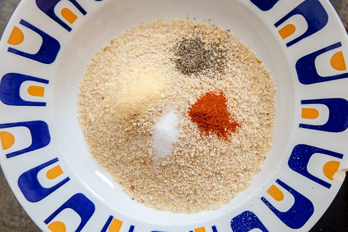 breadcrumbs in a bowl with spices on top not mixed in