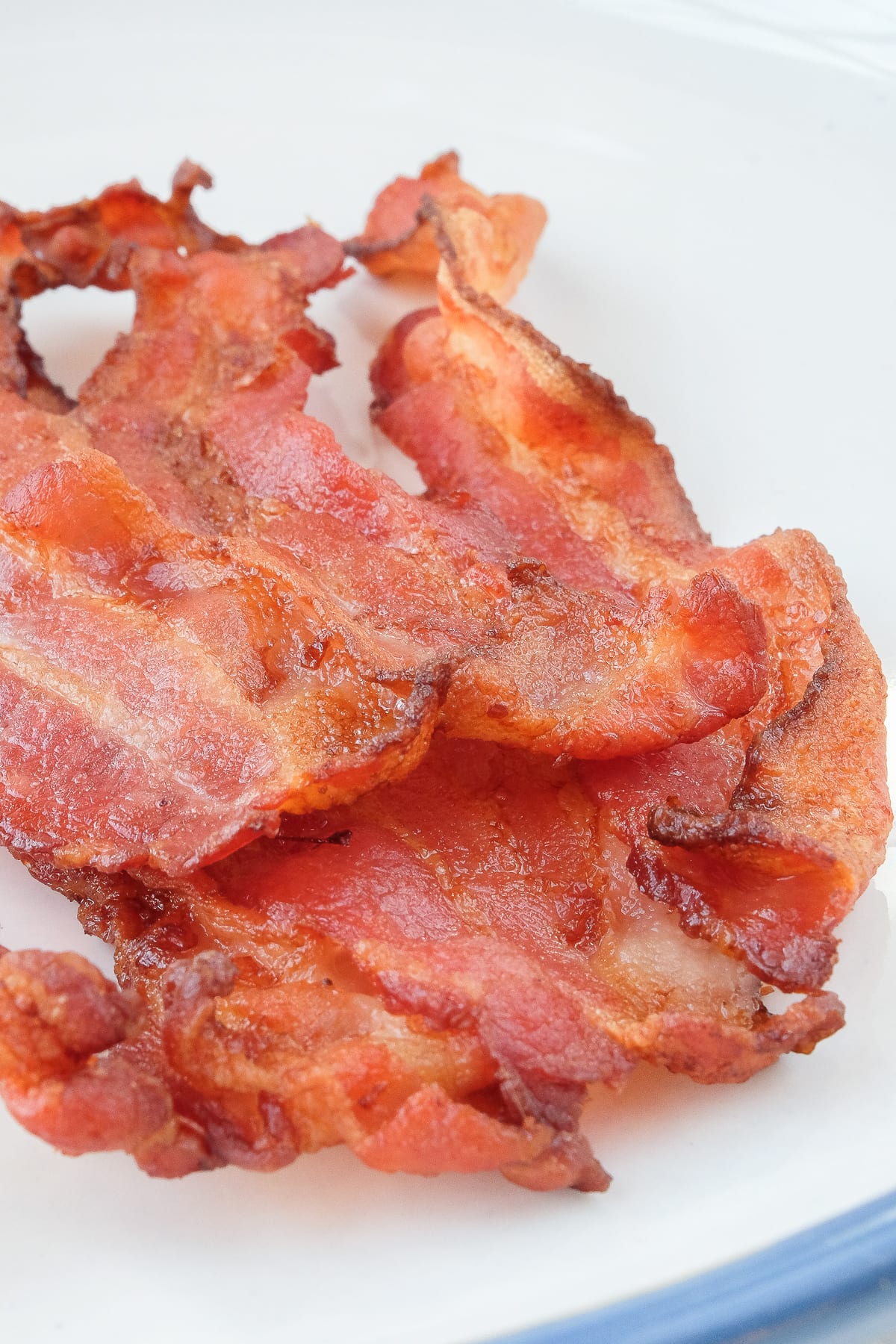crispy air bacon on a large plate with blue rim