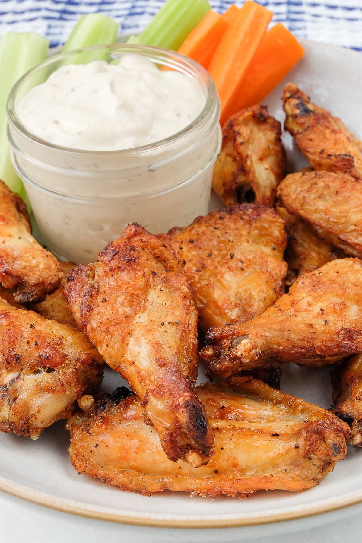 air fried crispy chicken wings on bowl with dip and cut vegetable sticks