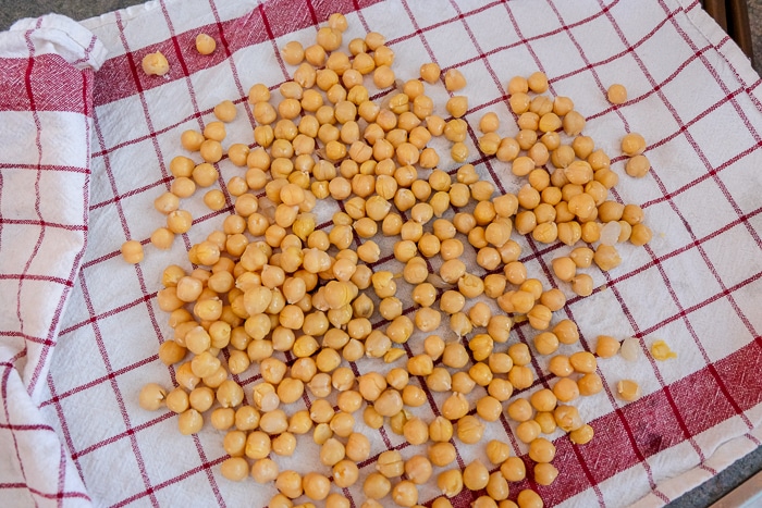 cooked chickpeas drying on red and white dish towel