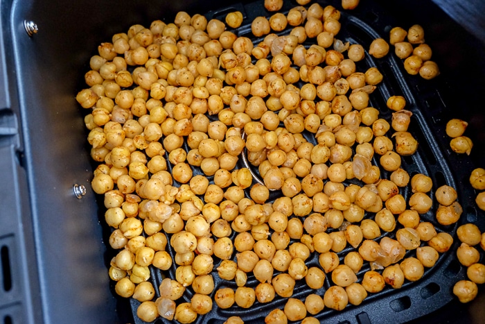 chickpeas spread out in black air fryer tray