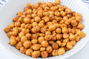 crispy chickpeas in white bowl with towel behind