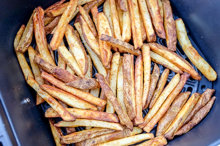 cooked french fries in black air fryer tray
