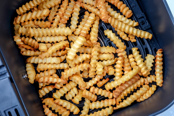 crispy golden brown fries in black air fryer tray