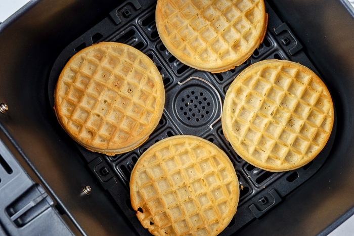 crispy brown frozen waffles in black air fryer tray