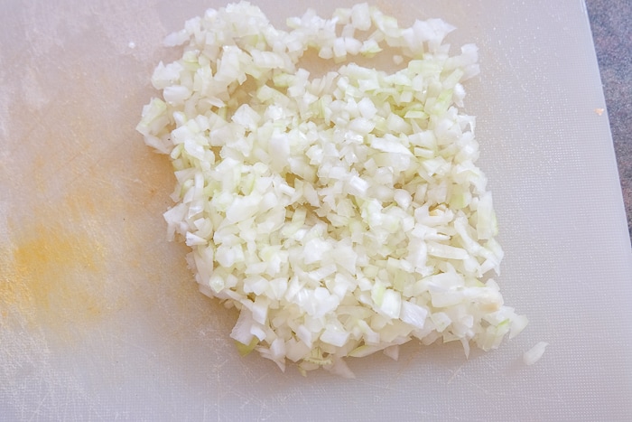 finely chopped onion on white plastic cutting board