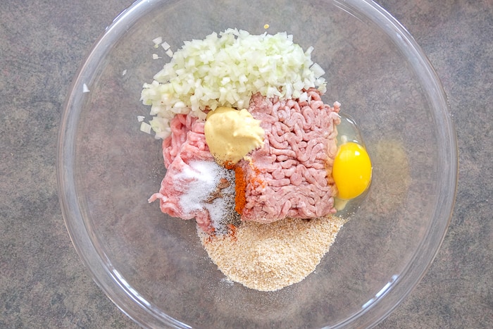 meatball ingredients in clear glass bowl on counter top.