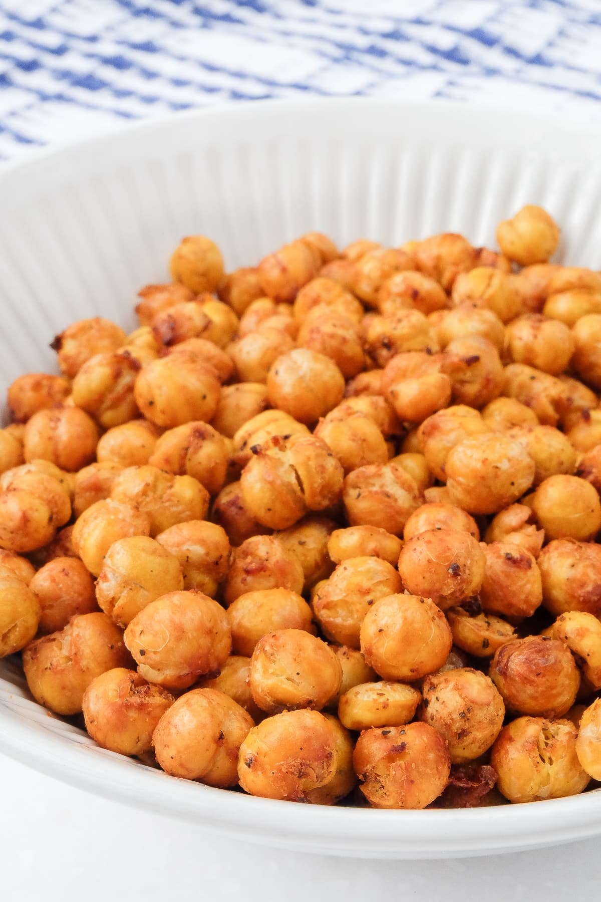 bowl of cooked chickpeas with dishtowel behind.