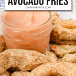 breaded pieces of avocado in bowl with small jar of orange dipping sauce and text overlay saying "air fryer avocado fries"