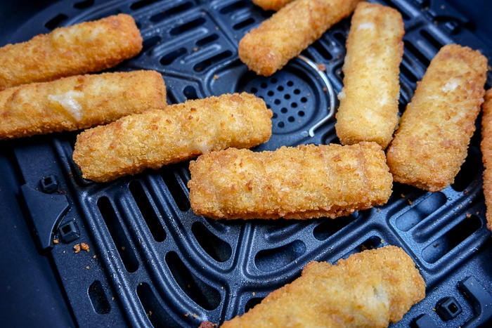 crispy fish sticks in dark air fryer tray