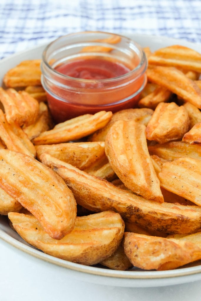cooked potato wedges in bowl with ketchup
