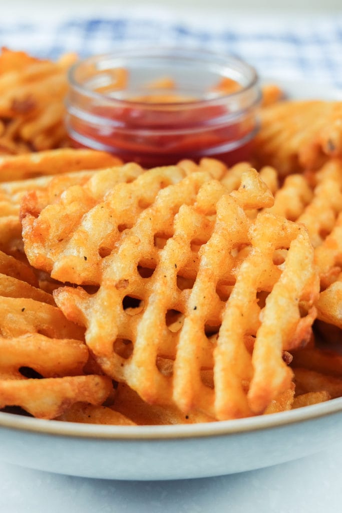 crispy waffle fries in bowl with ketchup in dish