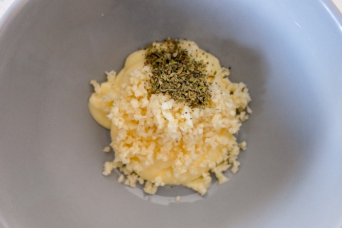 butter chopped garlic and Italian spice in white mixing bowl