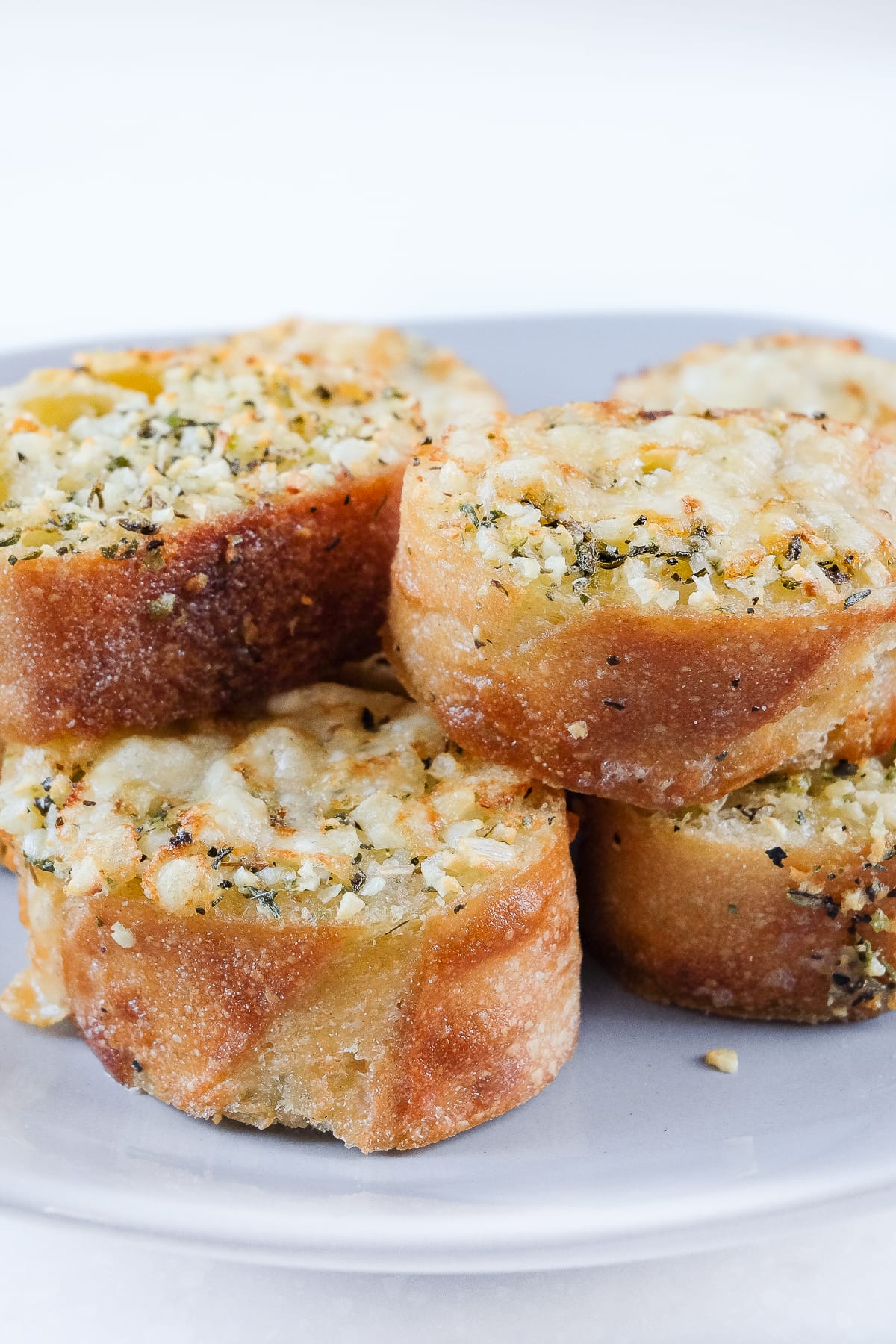 crispy garlic bread stacked on grey plate