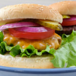 cooked hamburgers with buns on large plate