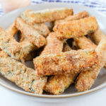breaded zucchini fries in bowl with towel behind