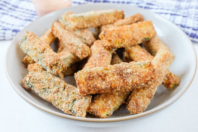 breaded zucchini fries in bowl with towel behind
