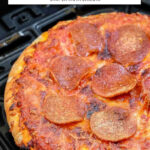 Cooked pizza in black air fryer basket with text overlay "air fryer frozen pizza".