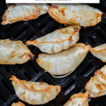 cooked potstickers with crispy edges in air fryer with text overlay "frozen potstickers in the air fryer".