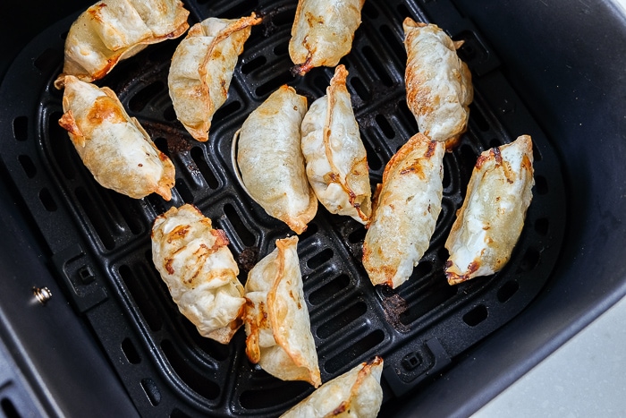 cooked dumplings in black air fryer tray