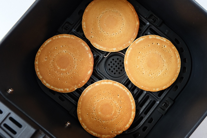 cooked frozen pancakes in black air fryer tray