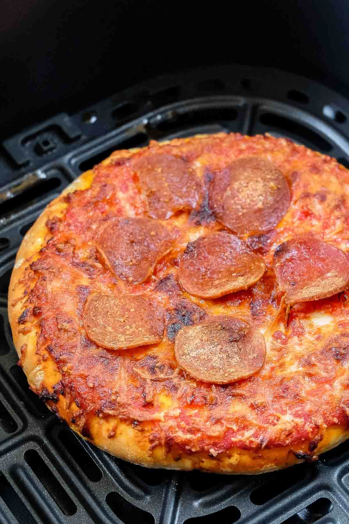 personal sized pizza with pepperoni on black air fryer tray