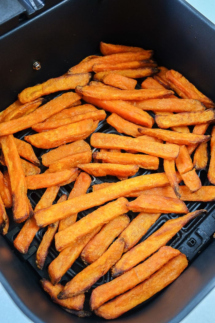 cooked sweet potato fries in black air fryer tray