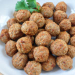 cooked meatballs in bowl with parsley behind