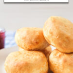 cooked biscuits stacked on white plate with text "canned biscuits in the air fryer".