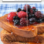 stacked pieces of French Toast with berries and syrup and text overlay 