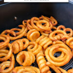 curly fries in black air fryer basket with text overlay 