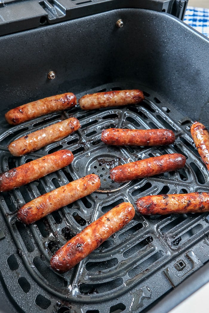 cooked breakfast sausages in black air fryer tray