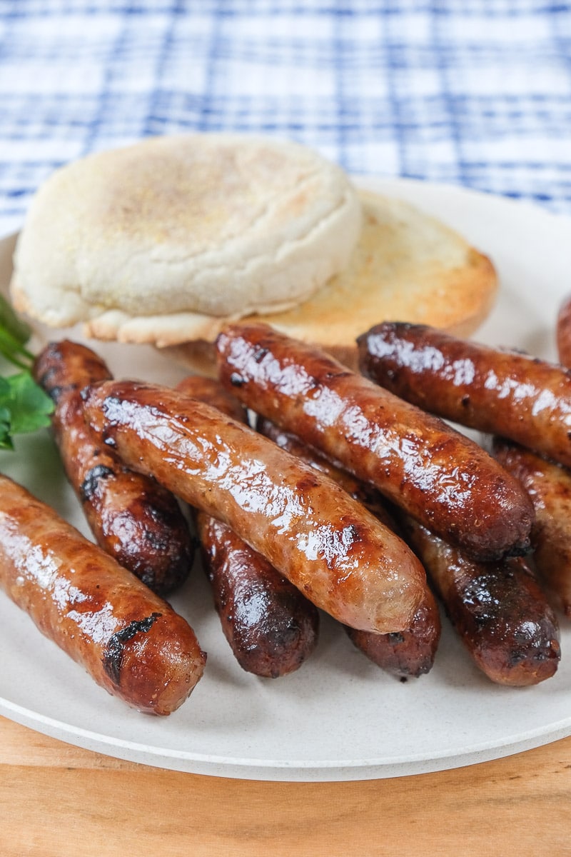 breakfast sausages on plate with toasted english muffin behind