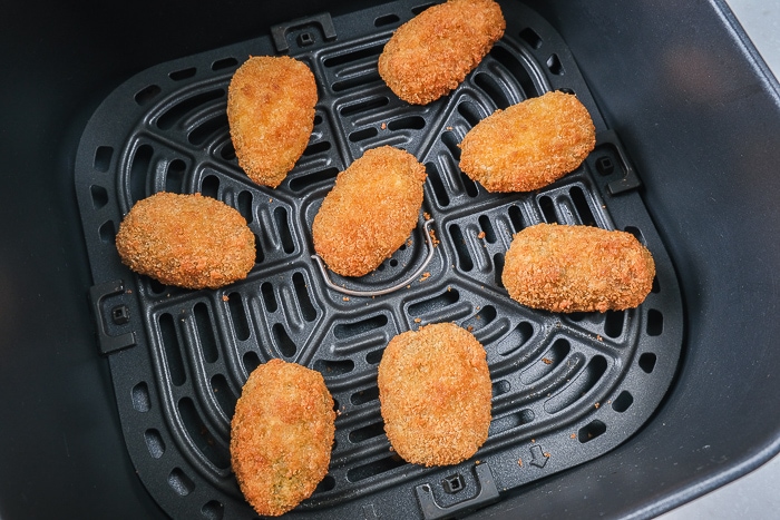 crispy jalapeno poppers in a black air fryer tray