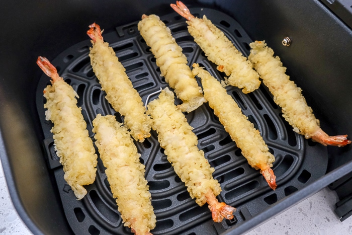 raw frozen shrimp tempura in black air fryer tray