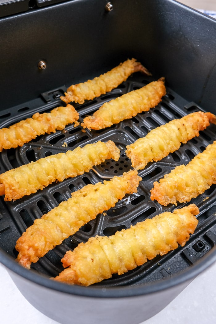 crispy browned shrimp tempura in black air fryer tray