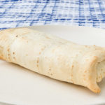 crispy white burrito on plate with blue cloth behind