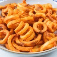 crispy curly fries in bowl on counter top