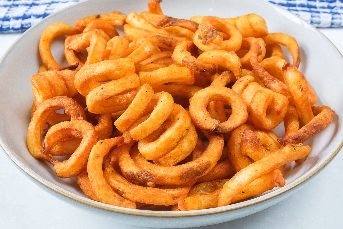 crispy curly fries in bowl on counter top