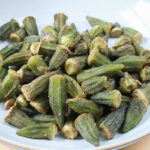 green okra in bowl on wooden board