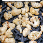 cooked cauliflower with crispy edges in air fryer with text overlay 